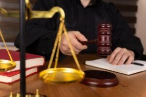 Judge holding a gavel beside the scales of justice