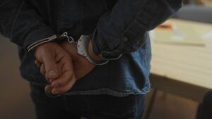 Person in handcuffs with hands behind their back