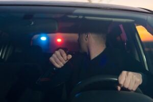 Driver pulled over at night with police lights behind him