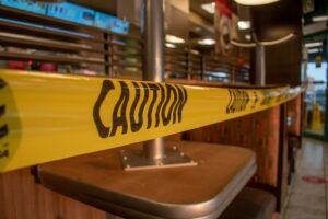 Caution tape across a closed restaurant bar