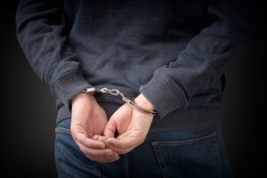 An arrested man with his hands handcuffed behind his back. What is the difference between murder and manslaughter?