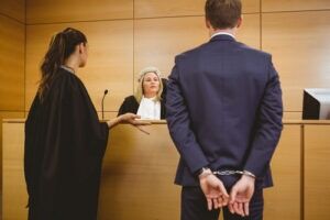 Handcuffed defendant standing before a judge with his attorney
