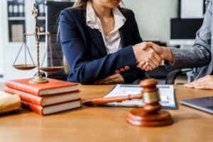 Lawyer shaking hands with a client across a desk