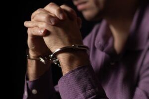 A man with his hands clasped after being arrested. Is there a difference between voluntary and involuntary manslaughter?