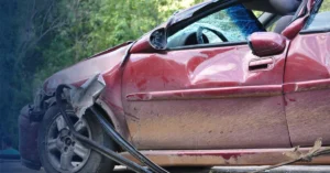 Wrecked red car after a hit-and-run crash