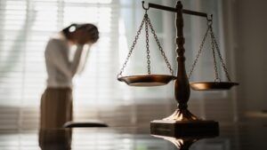 Distressed woman standing near the scales of justice