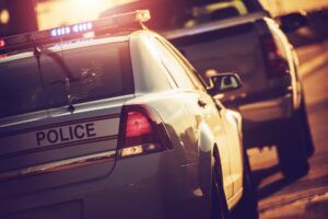 Police car with lights on at a traffic stop at night