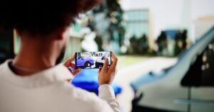 person photographing damaged vehicles at accident scene using smartphone