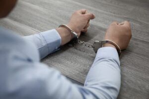 A person in handcuffs during an arrest related to sex crime charges in Phoenix.