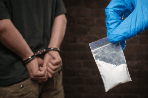 Evidence and a handcuffed suspect after a drug arrest in Tucson.